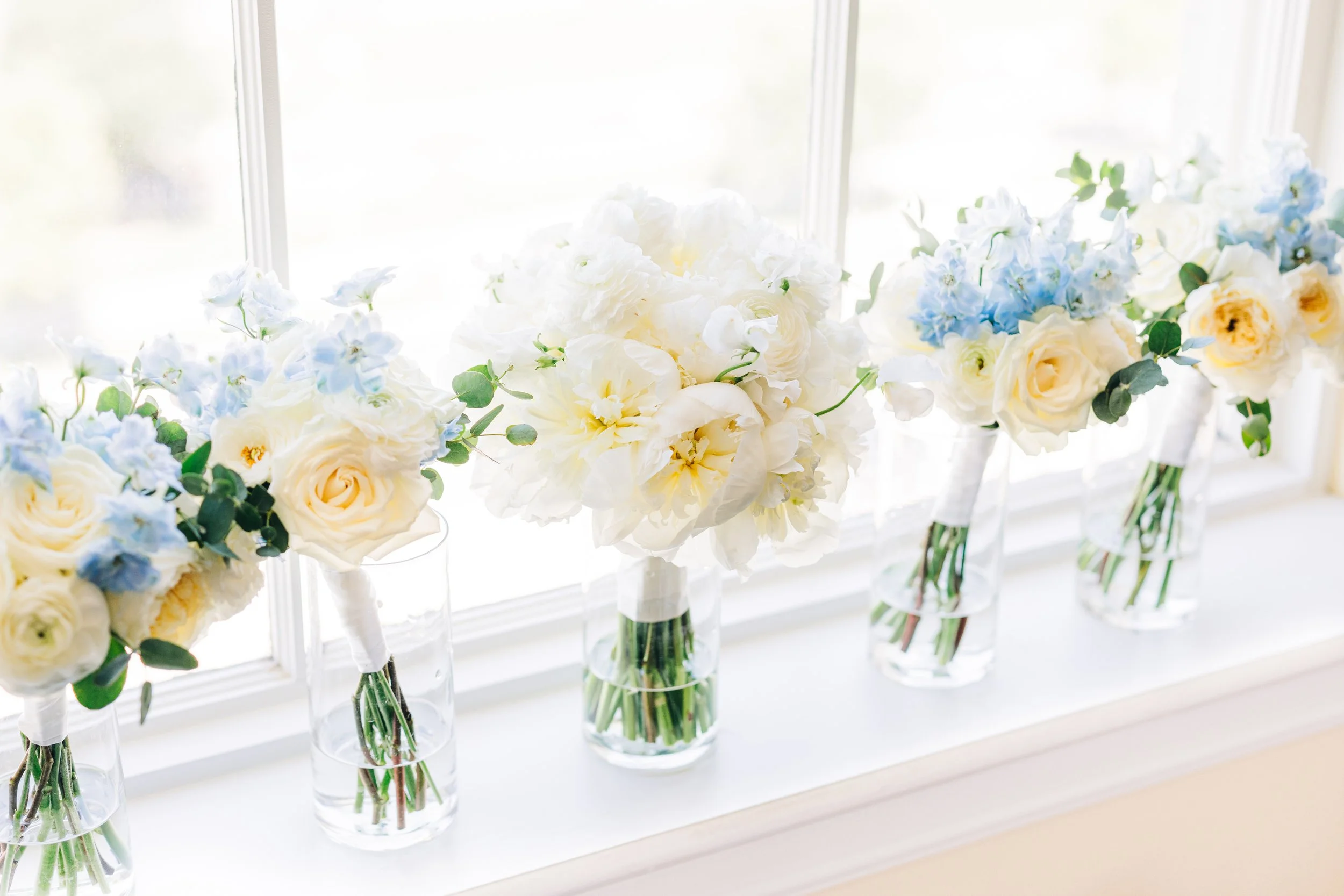 Bride and bridesmaids bouquets in window at baton rouge wedding