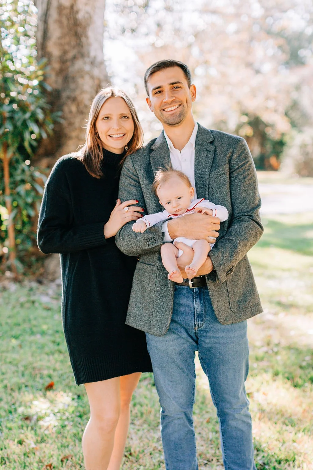 mom standing with dad holding newborn baby during family portrait session in baton rouge