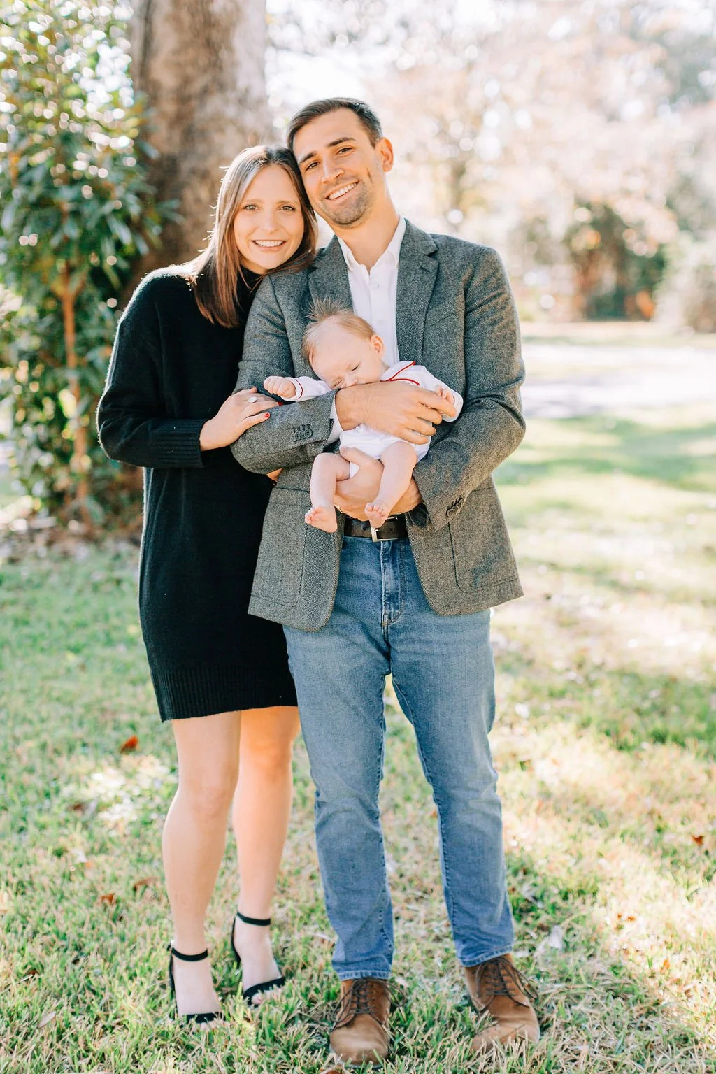 mom standing with dad holding newborn baby during family portrait session in baton rouge