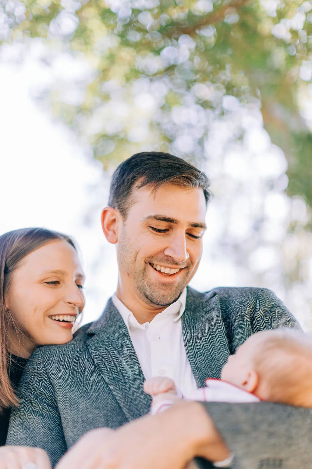 close-up of mom standing with dad holding and looking down at newborn baby during family portrait session in baton rouge
