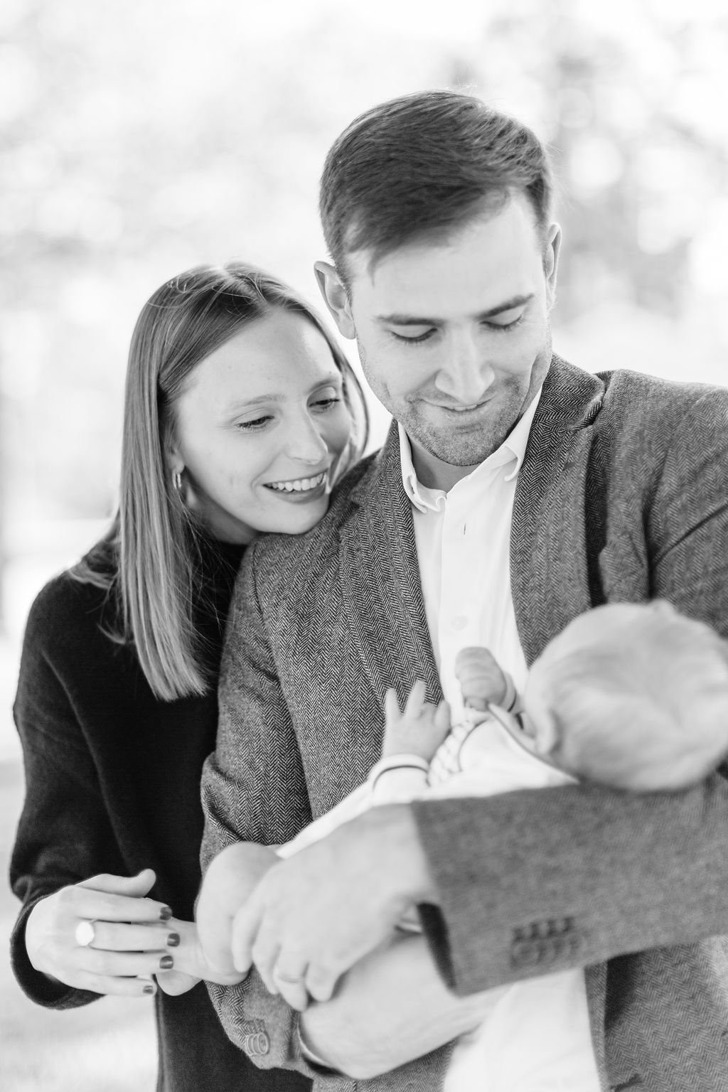 mom standing with dad holding newborn baby during family portrait session in baton rouge