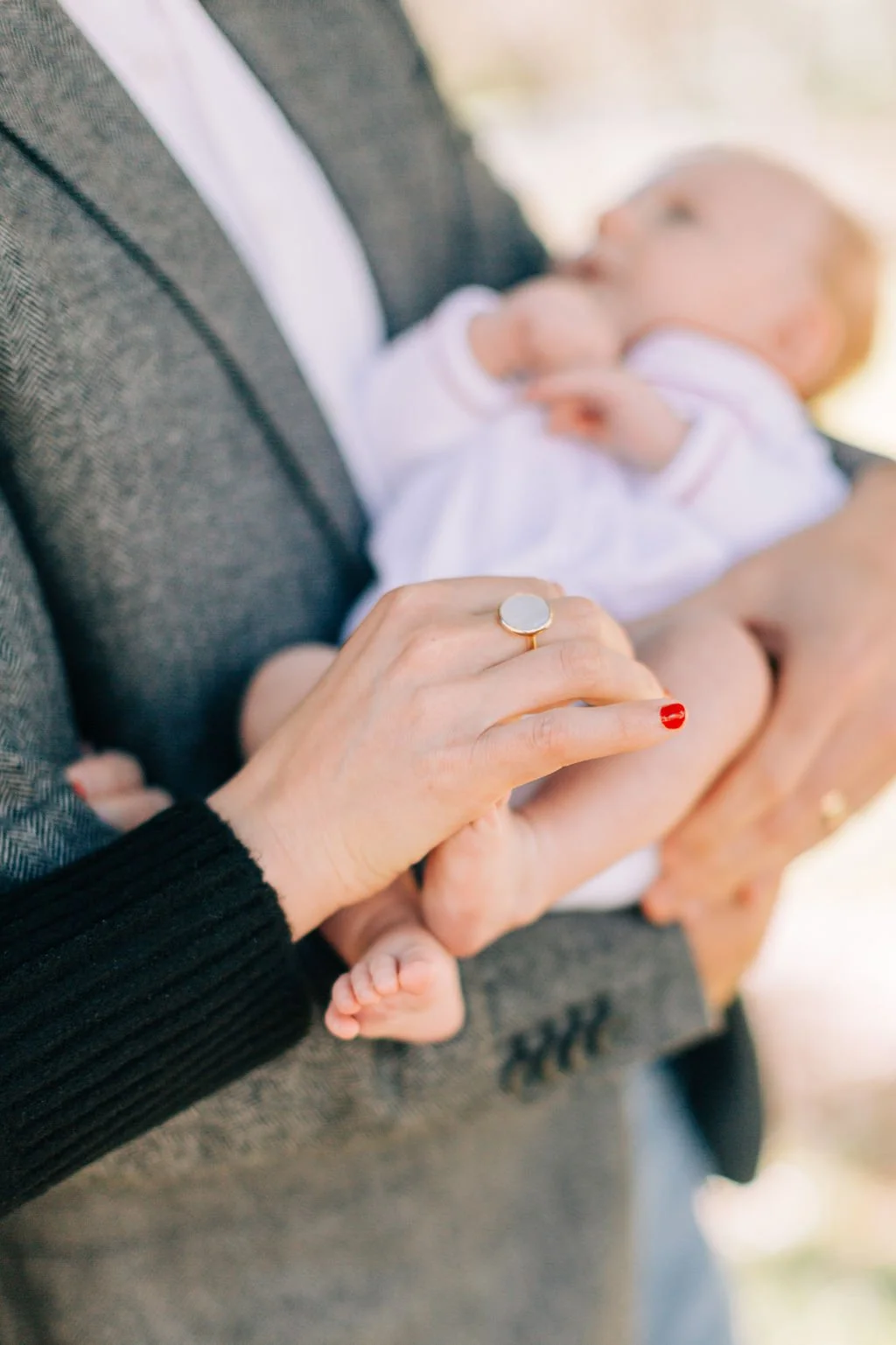 close-up of mom and dad holding newborn baby during family portrait session in baton rouge
