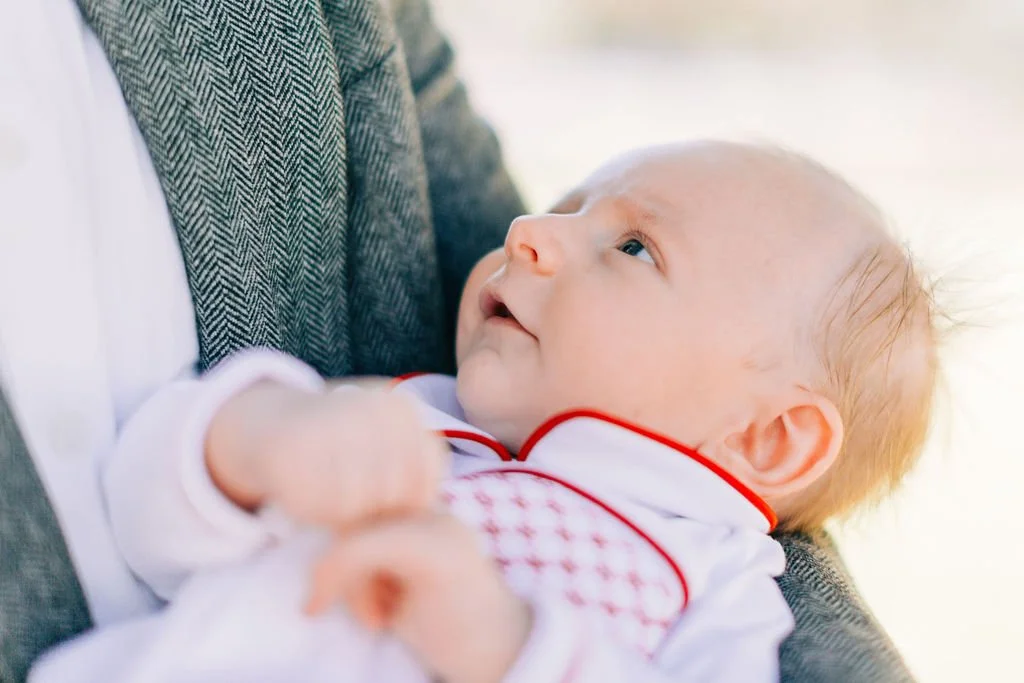 close-up of newborn baby being held by his dad during family portrait session in baton rouge