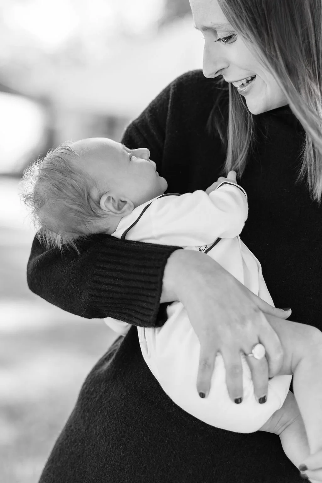 mom standing and holding newborn baby during family portrait session in baton rouge
