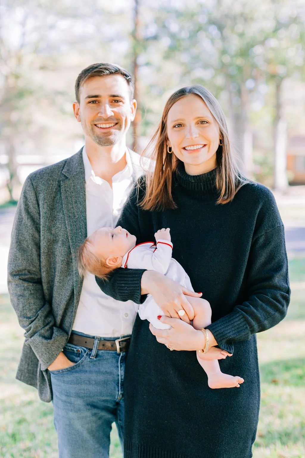 mom standing with dad holding newborn baby during family portrait session in baton rouge