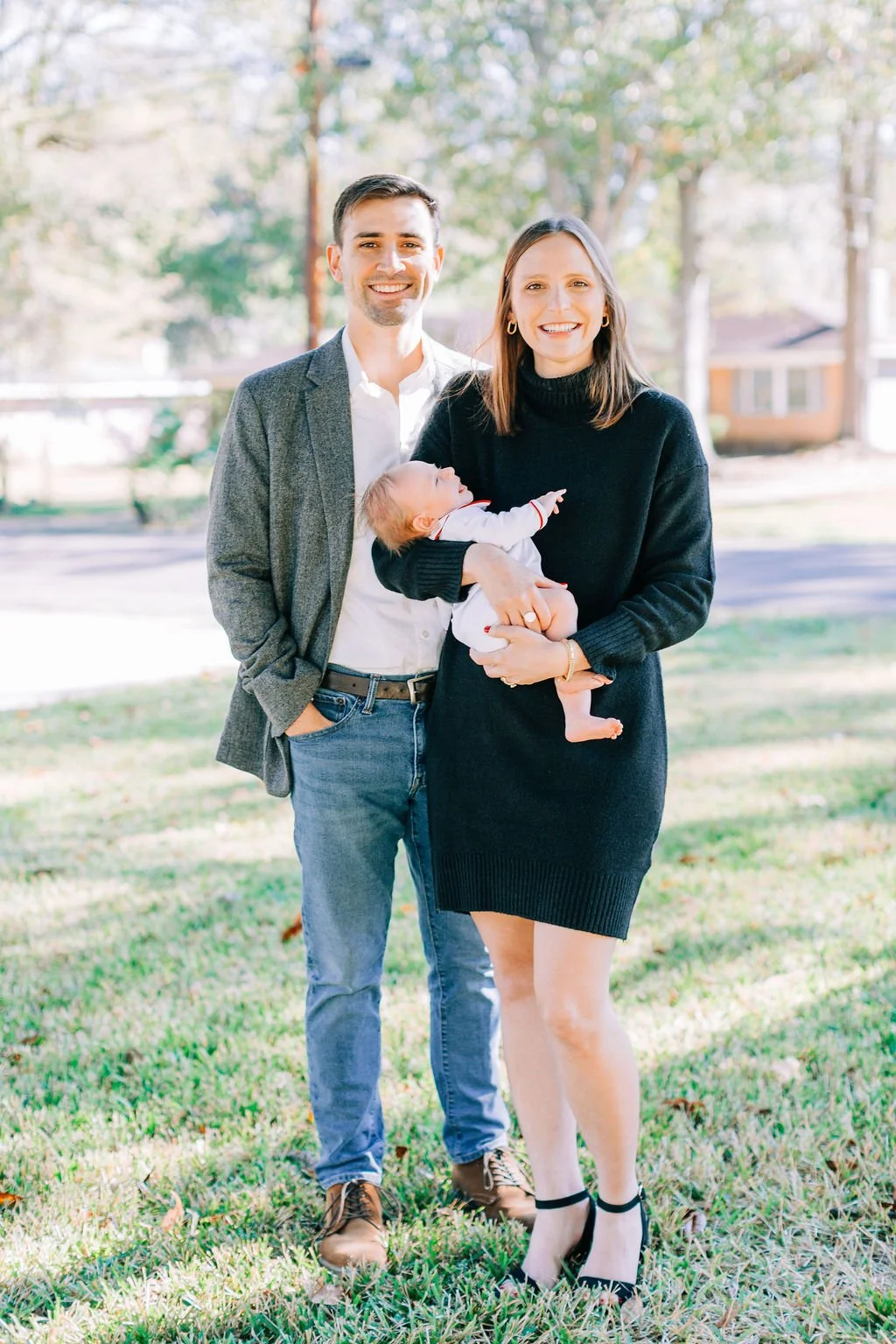 mom standing with dad holding newborn baby during family portrait session in baton rouge