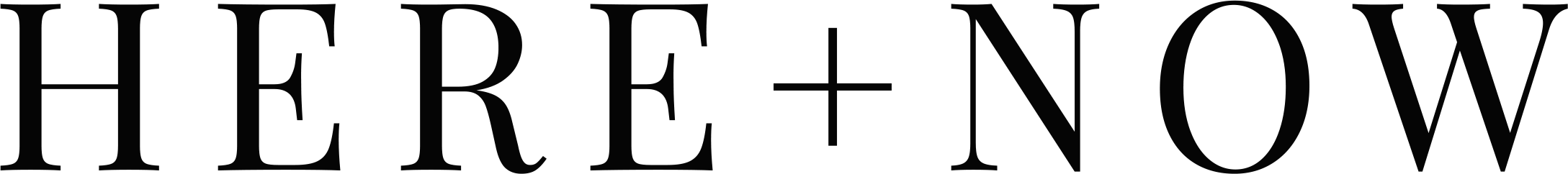 Black background with large, faint text that reads "HERE + NOW."