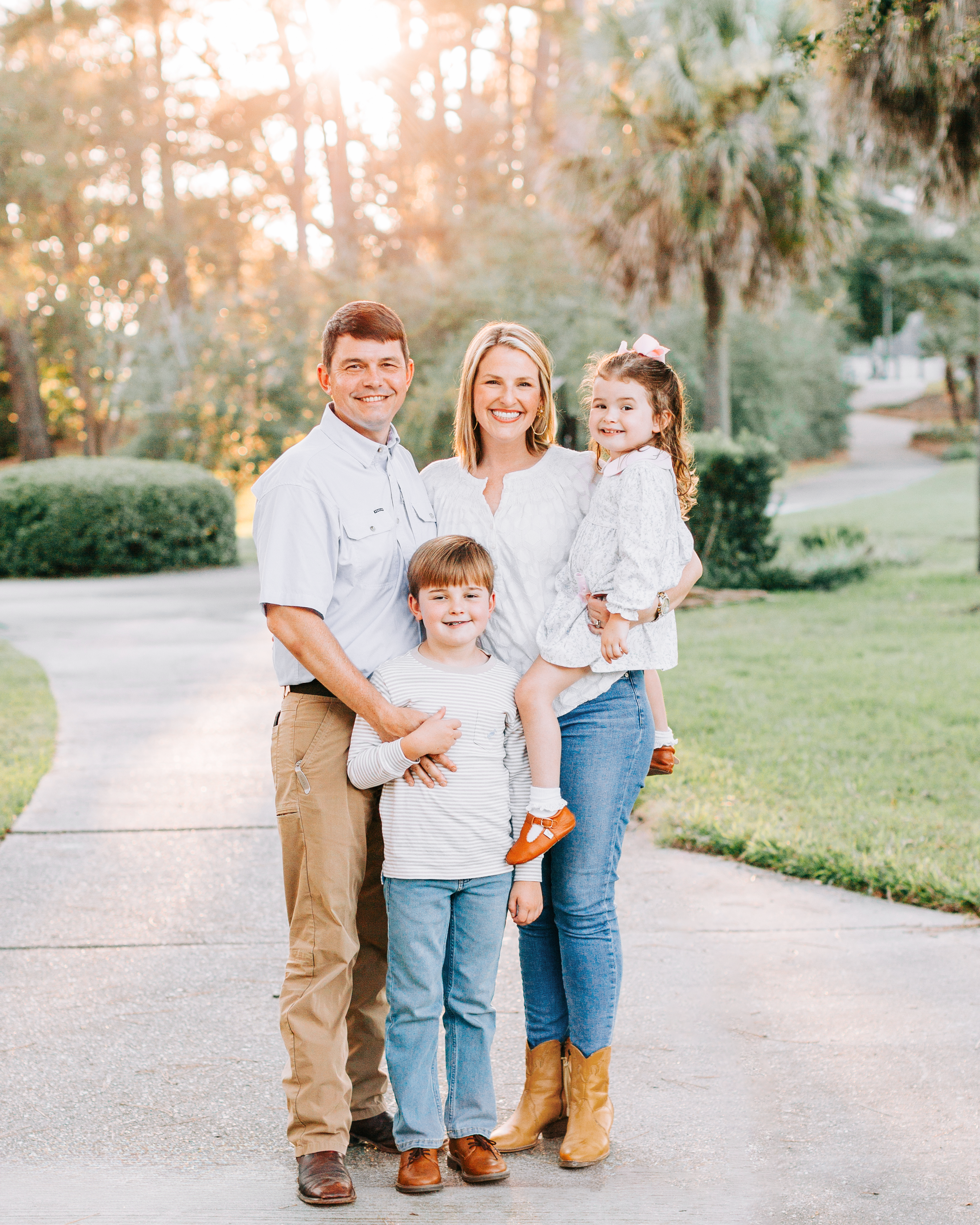 Family of four smiling together at sunset during outdoor session in Baton Rouge