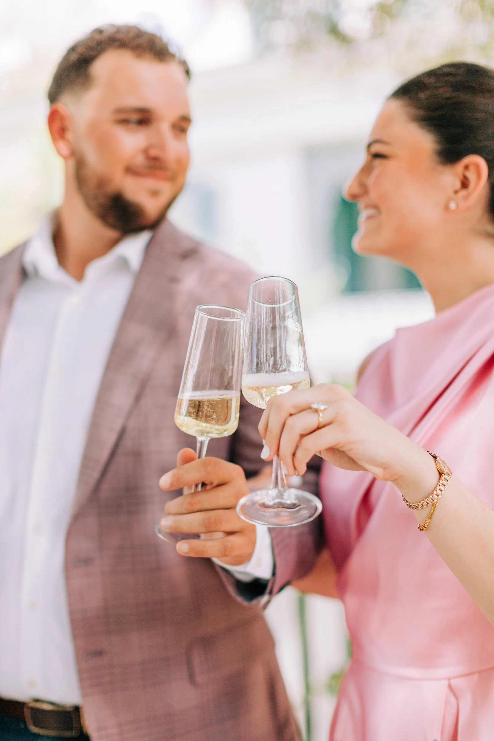 A man and woman holding champagne glasses and toasting at a celebration or event.