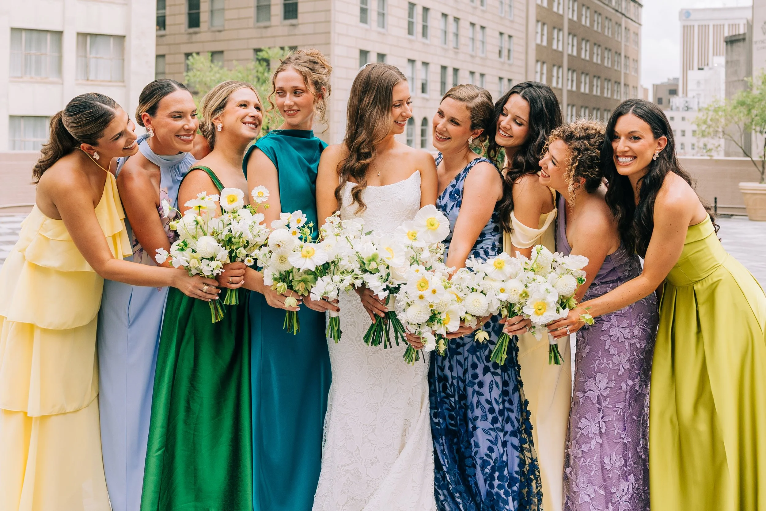 bride and bridesmaids huddling together with their bouquets during baton rouge wedding