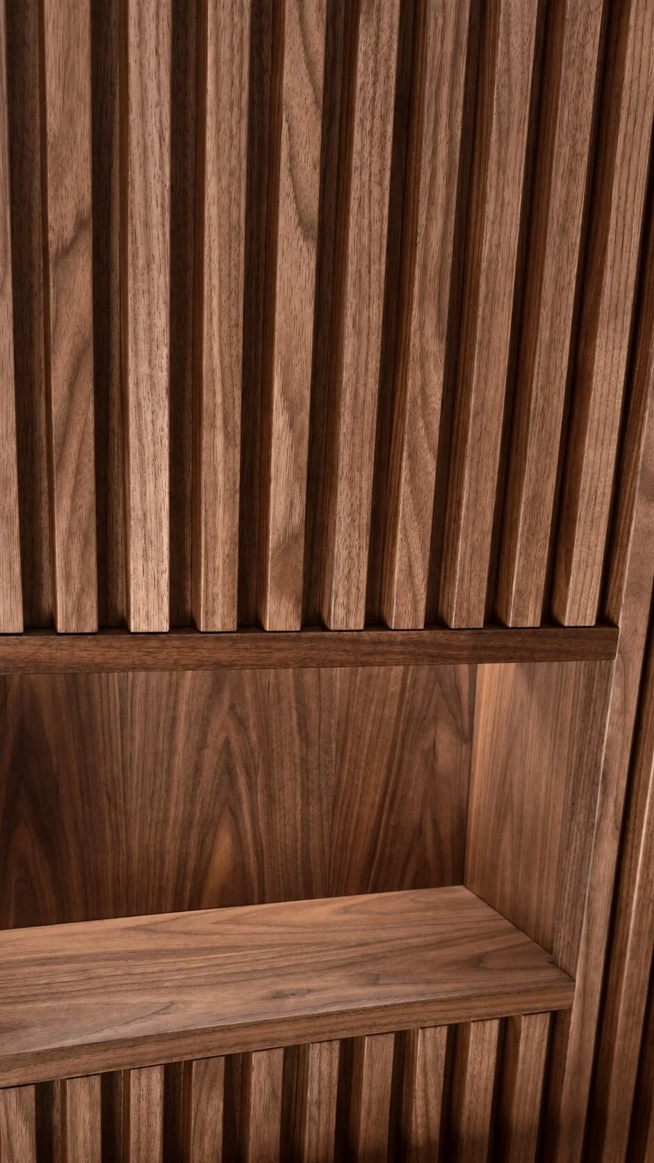Floor to ceiling slatted walnut bathroom wall panel with concealed warm LED back and shelf lighting designed, built and installed by Motor City Woodshop Studio