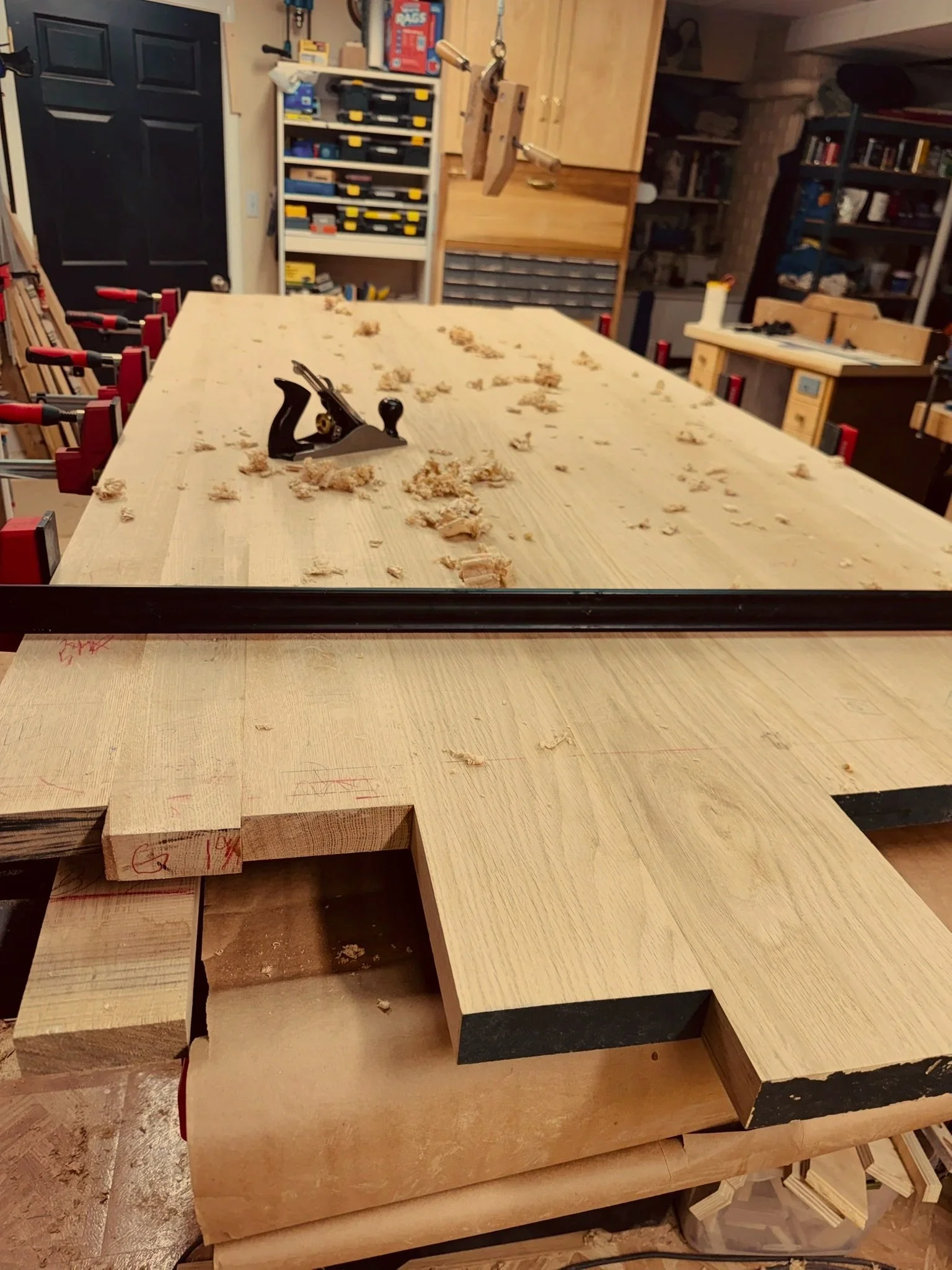 Motor City Woodshop smoothing and flattening a white oak table top with a hand plane.