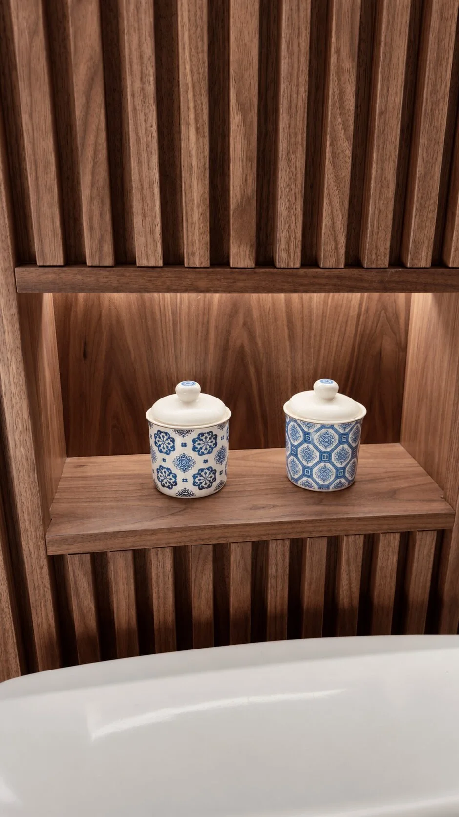Floor to ceiling slatted walnut bathroom wall panel with concealed warm LED back and shelf lighting designed, built and installed by Motor City Woodshop Studio