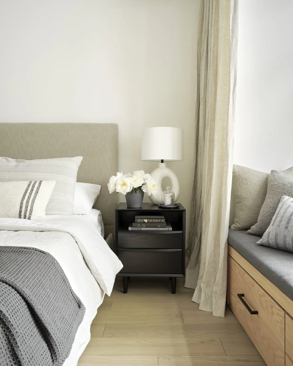 Primary bedroom bed and nightstand with window seat view, Grace Street Victorian renovation Toronto