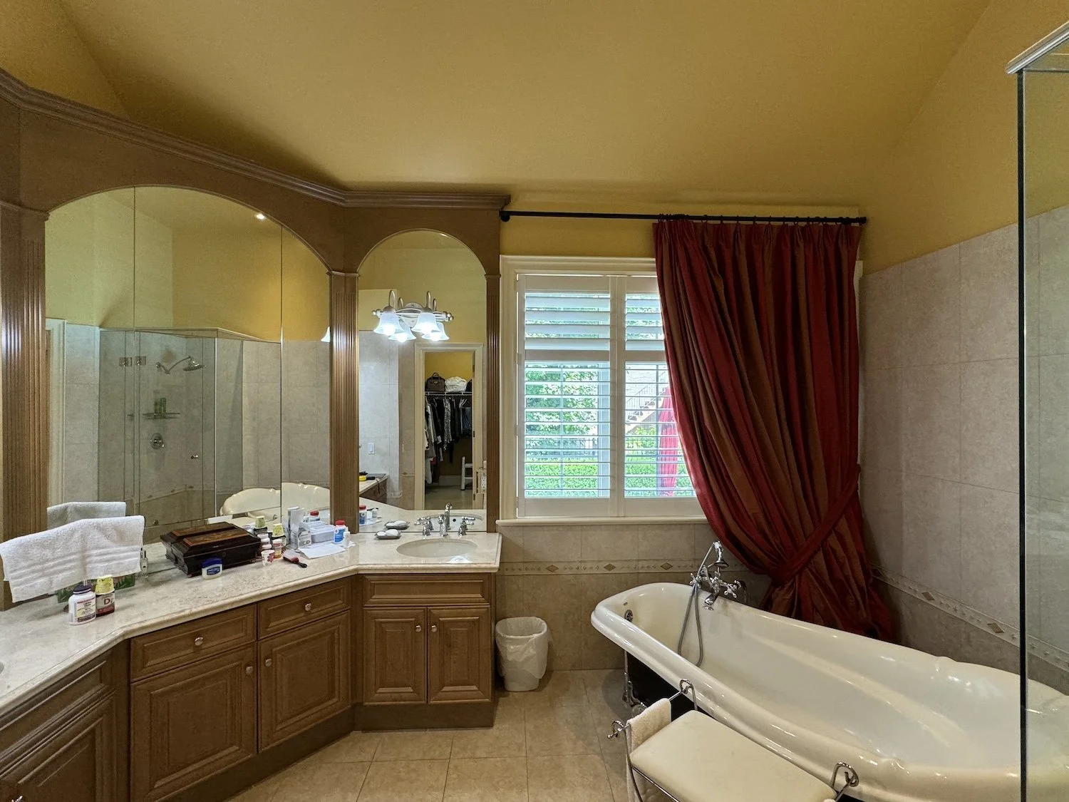 Primary ensuite before renovation, Unionville: corner vanity, angled freestanding tub, and view into closet