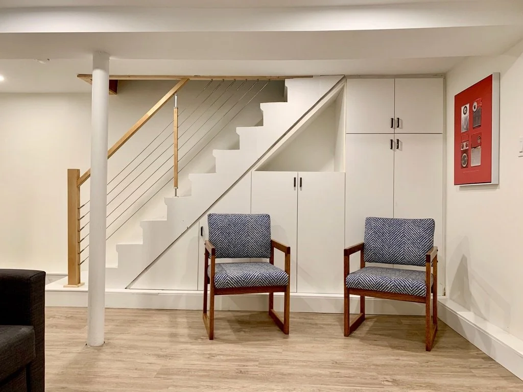 Finished basement stairwell with vinyl plank flooring, Grace Street Victorian renovation Toronto Airbnb