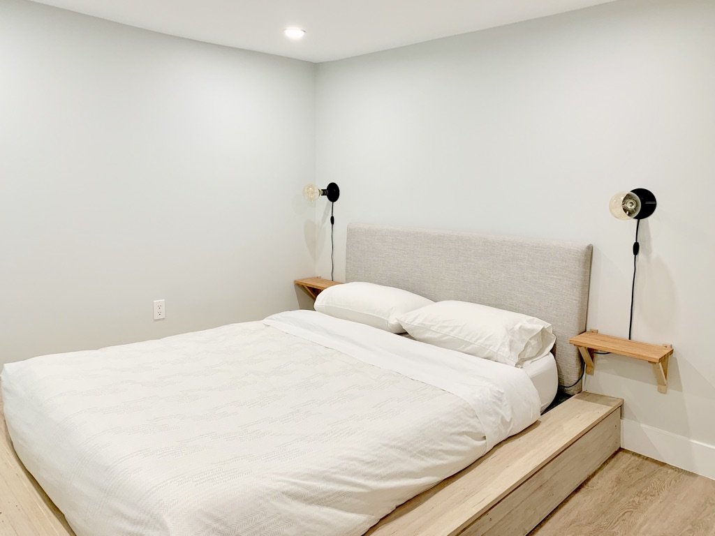 Finished platform bed built over the old furnace patch, Grace Street Victorian renovation Toronto basement Airbnb