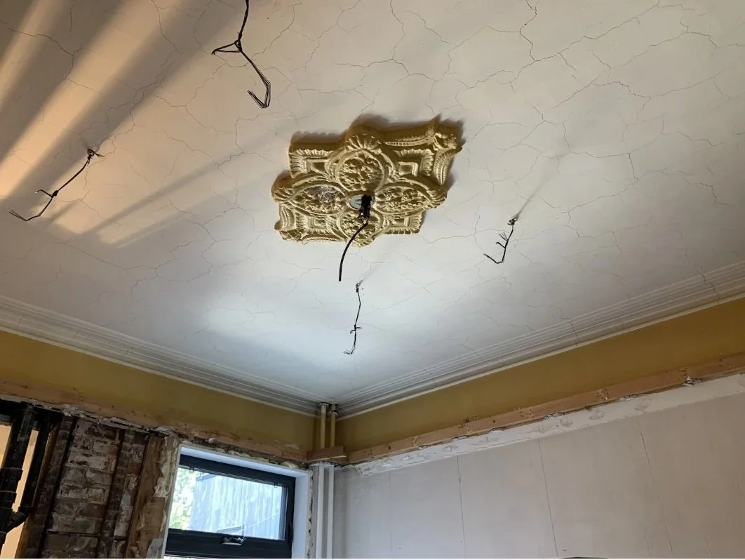 Original plaster ceiling medallion exposed above a false drop ceiling, Grace Street Victorian restoration Toronto