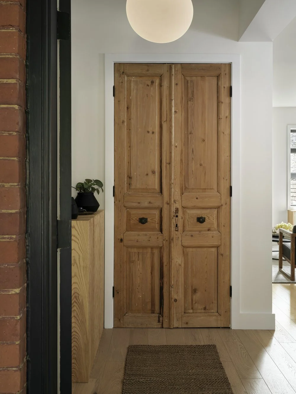 Salvaged Egyptian doors and hidden radiator console in the finished foyer, Grace Street Victorian renovation Toronto