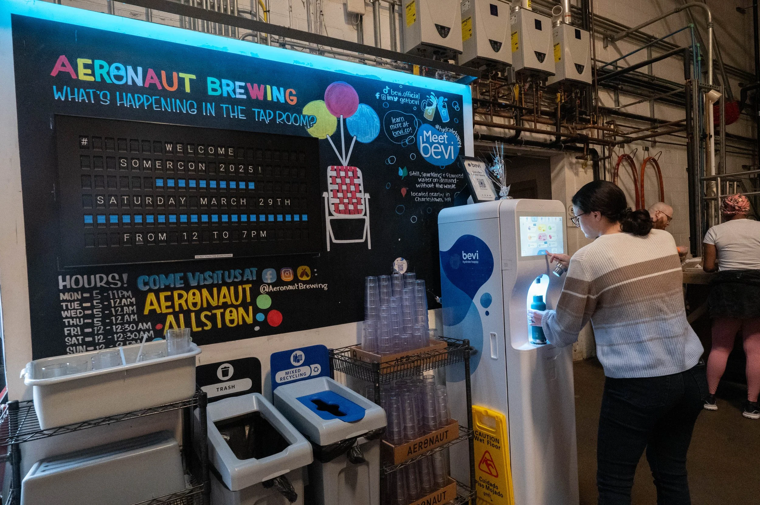 Near the building entrance is a sign welcoming attendees to the convention. Just past this sign is a small hallway leading to the area mapped out here, a private event space where SomerCon is being held.