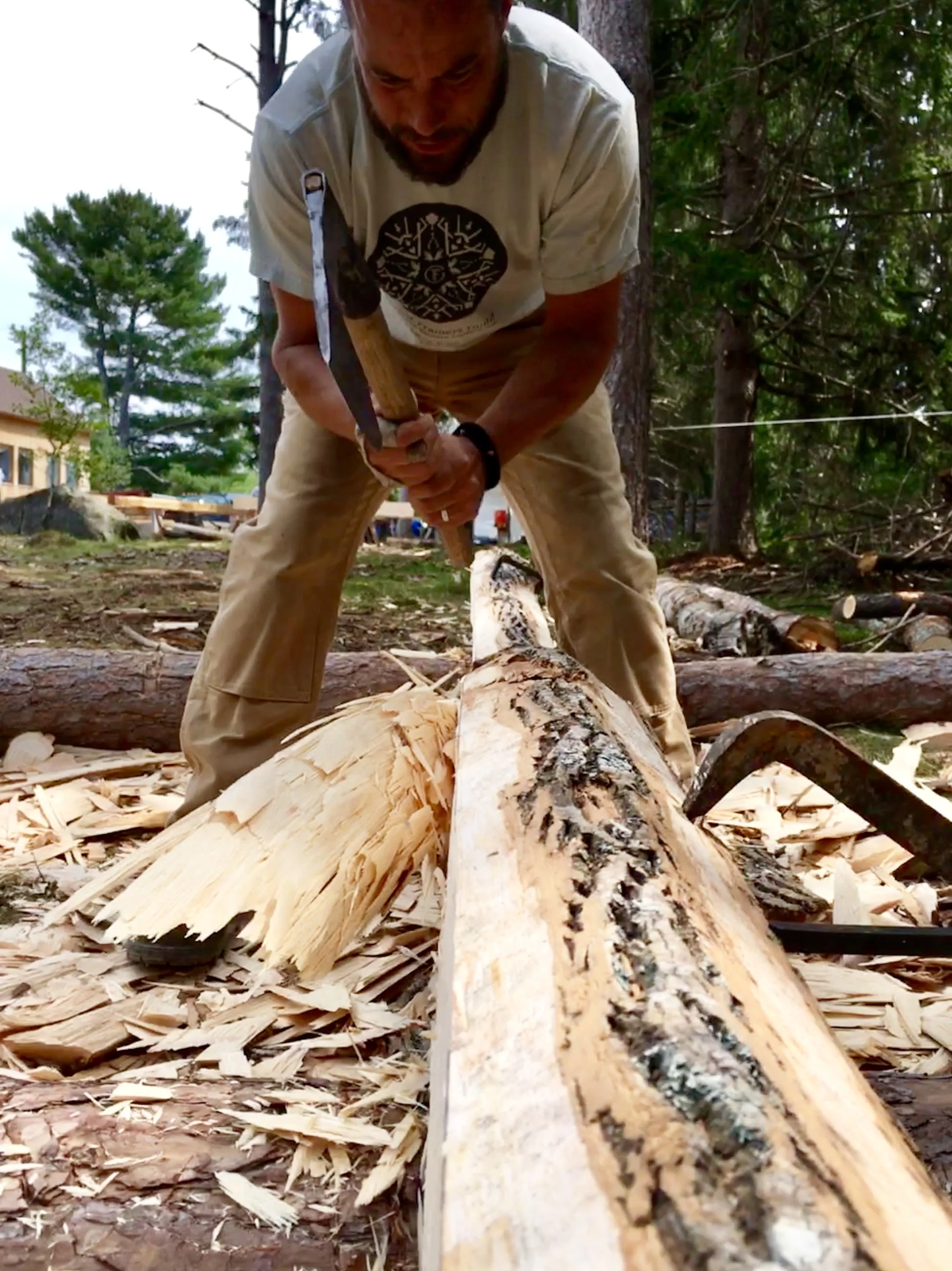 jordan finch hewing a timber with a broad axe.jpg