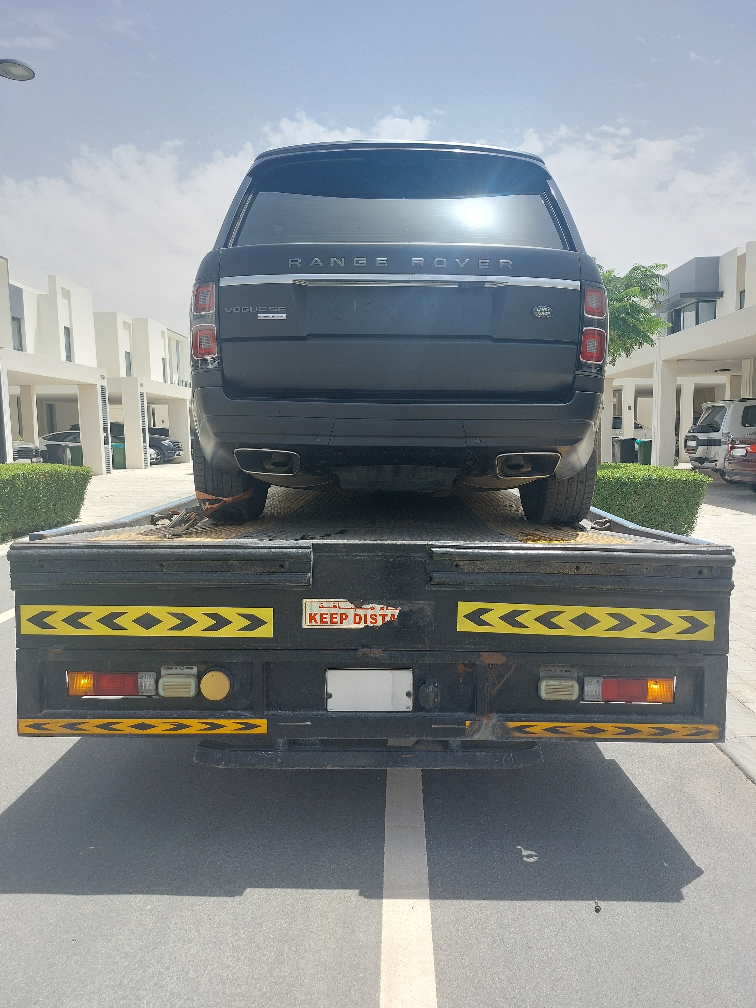 Standard recovery truck transporting an SUV from Dubai South to Downtown Dubai