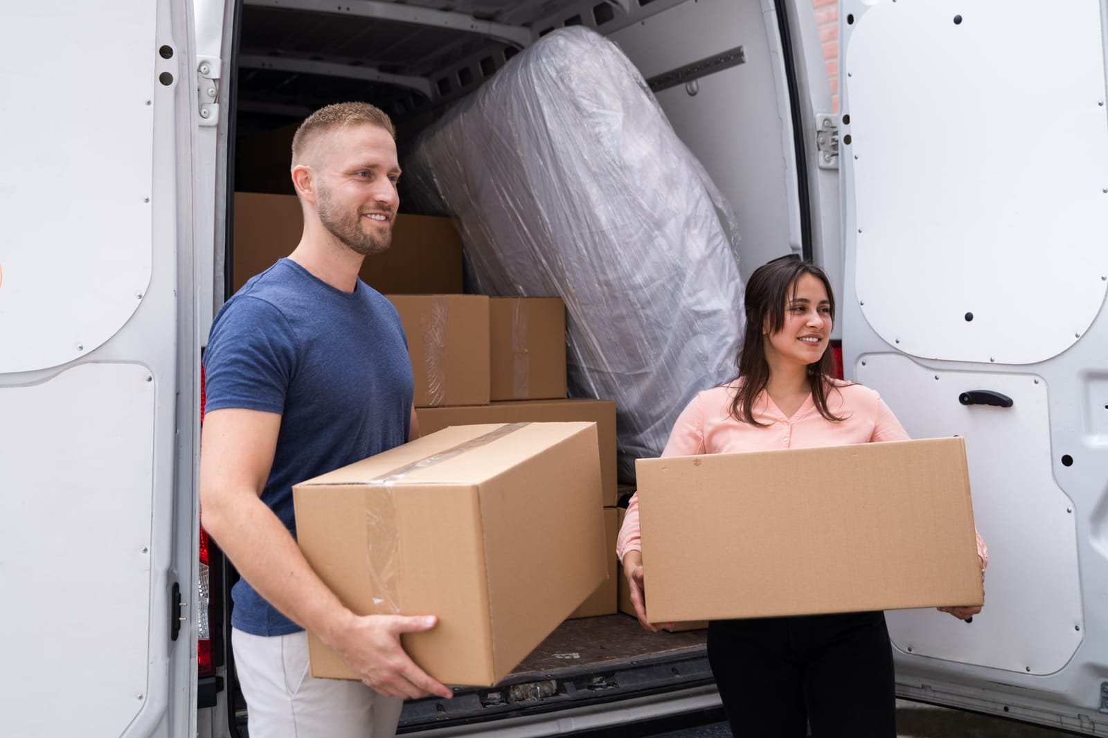 Couple moving boxes into the minivan