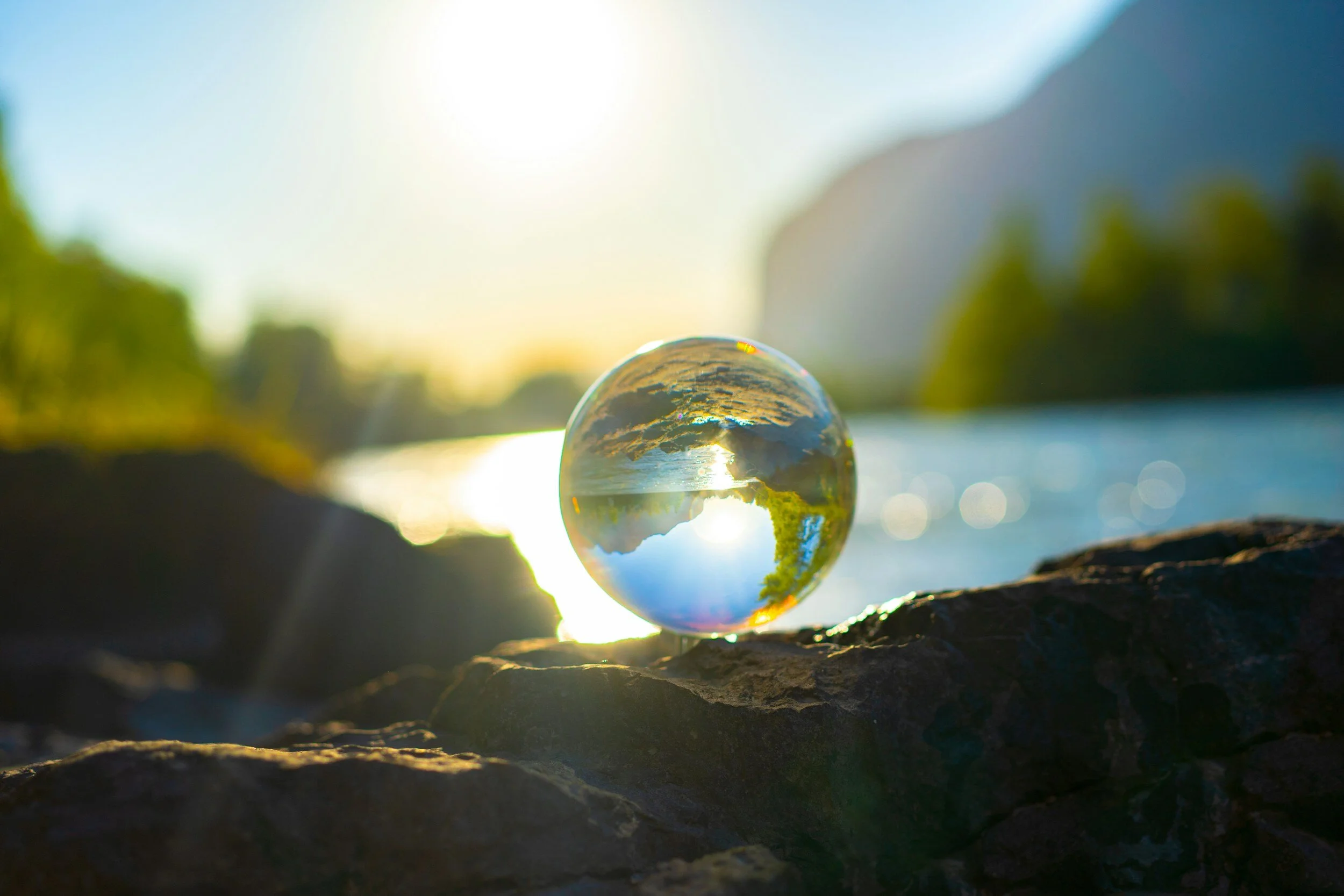 Globe in front of water with sunlight filtering through