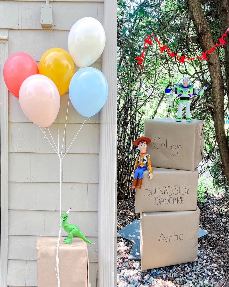 Rex from Toy Story wearing a birthday party hat and holding balloons