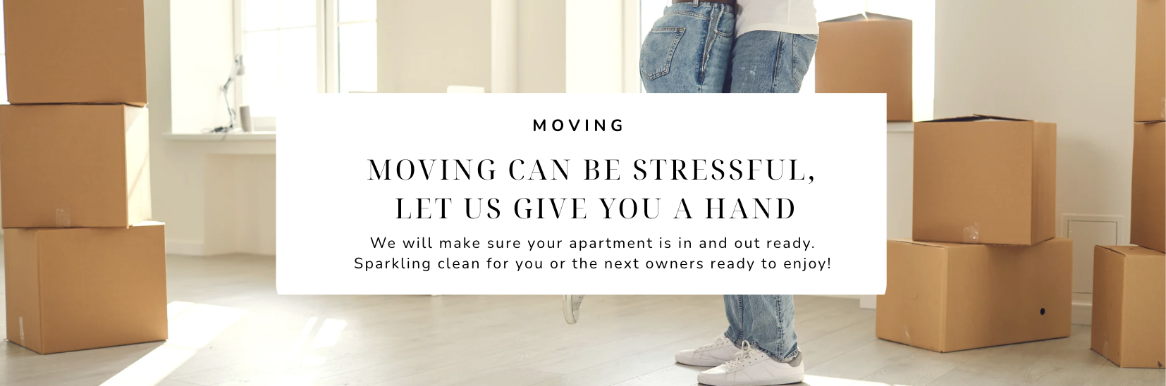 Moving boxes in a bright apartment with a person’s legs visible, holding the boxes, during a moving process.