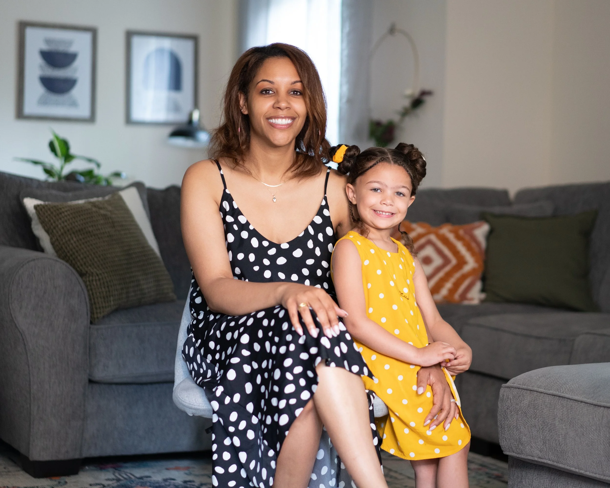 Happy mom and daughter sitting in the living room