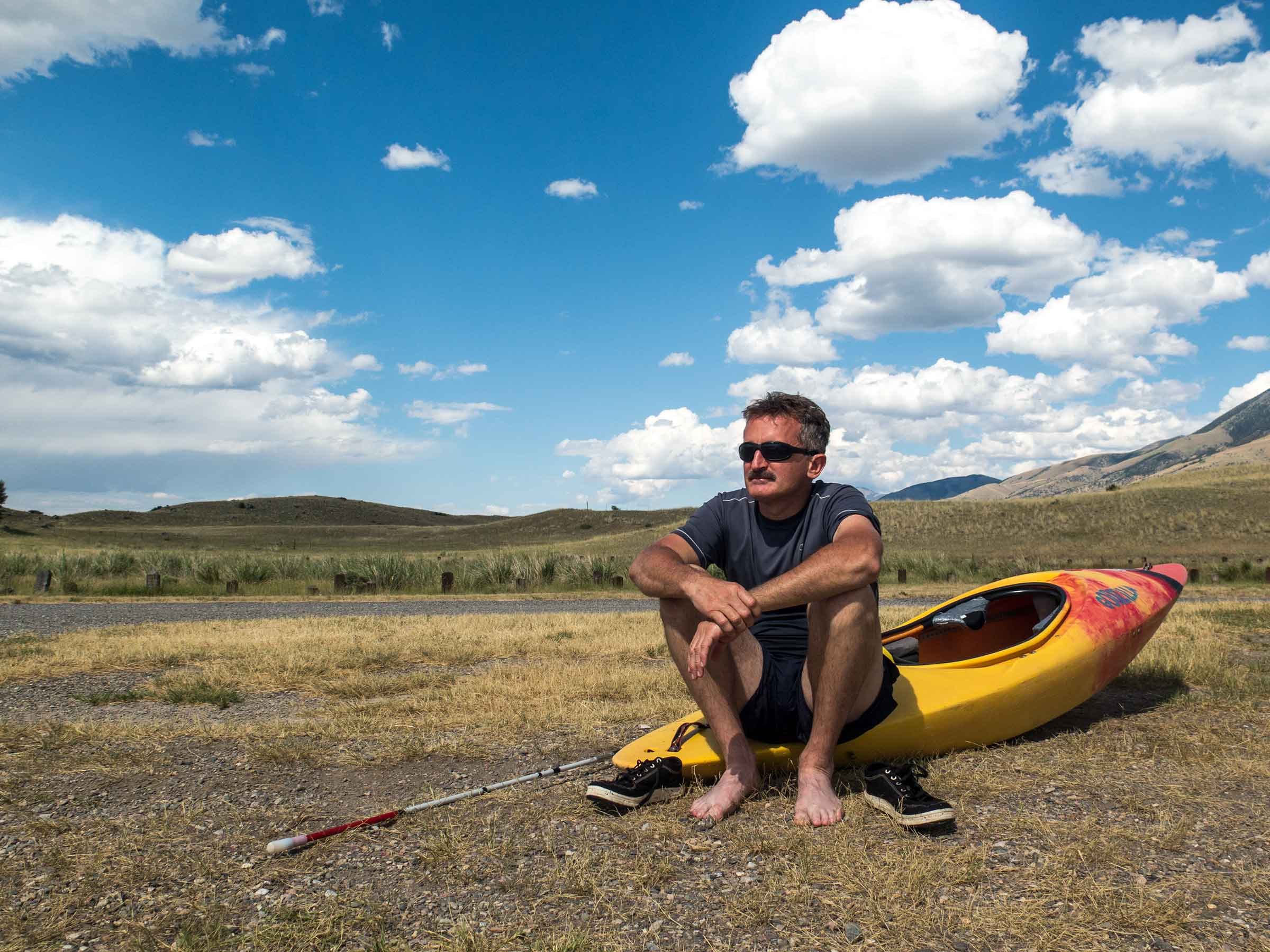 blind kayaker lonnie bedwell sits on his kayak on shore.jpg