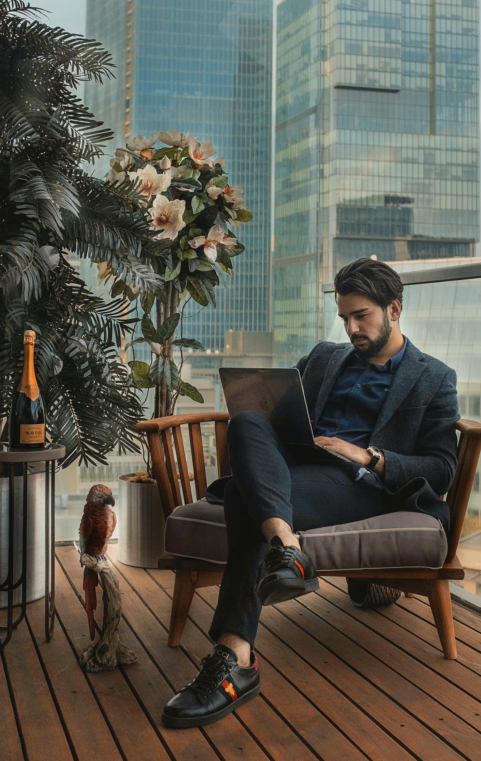 Male entrepreneur working on laptop on high-rise terrace — somatic therapy for burnout, stress, and deeper healing with a somatic therapist for high-achieving professionals Los Angeles