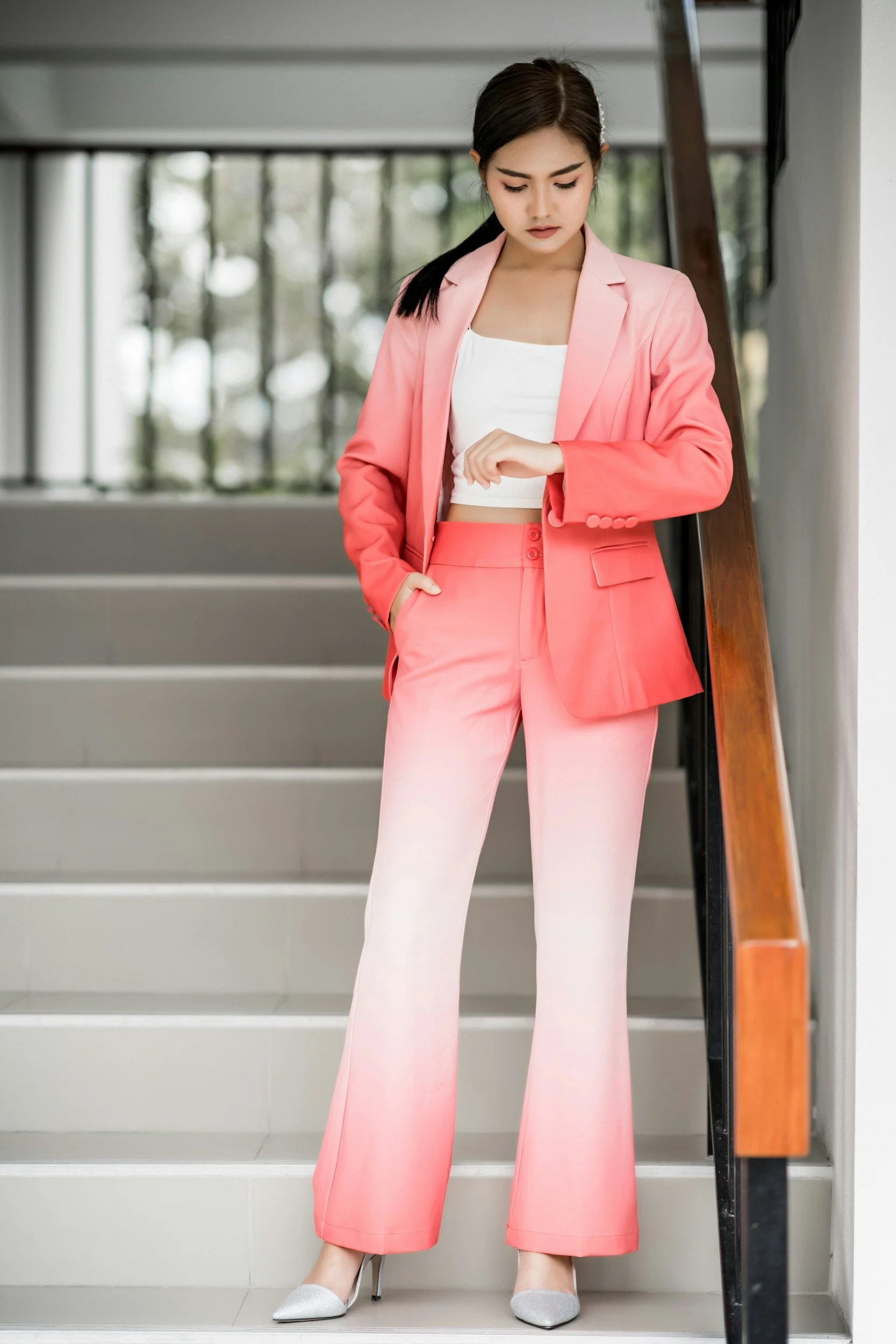 Female professional in a pink suit on staircase — somatic therapy for women entrepreneurs and high-achieving professionals in California
