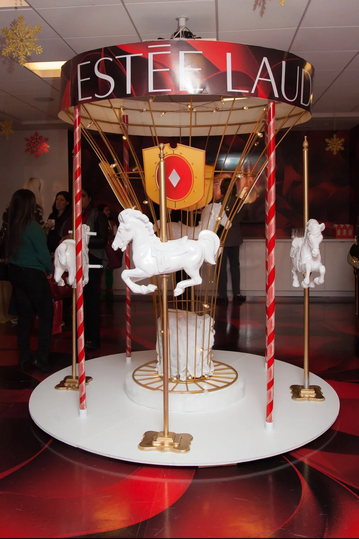 A carousel display with white horses. Custom Build ESTÉE LAUDER Designed brand activation Alexandria Design House 