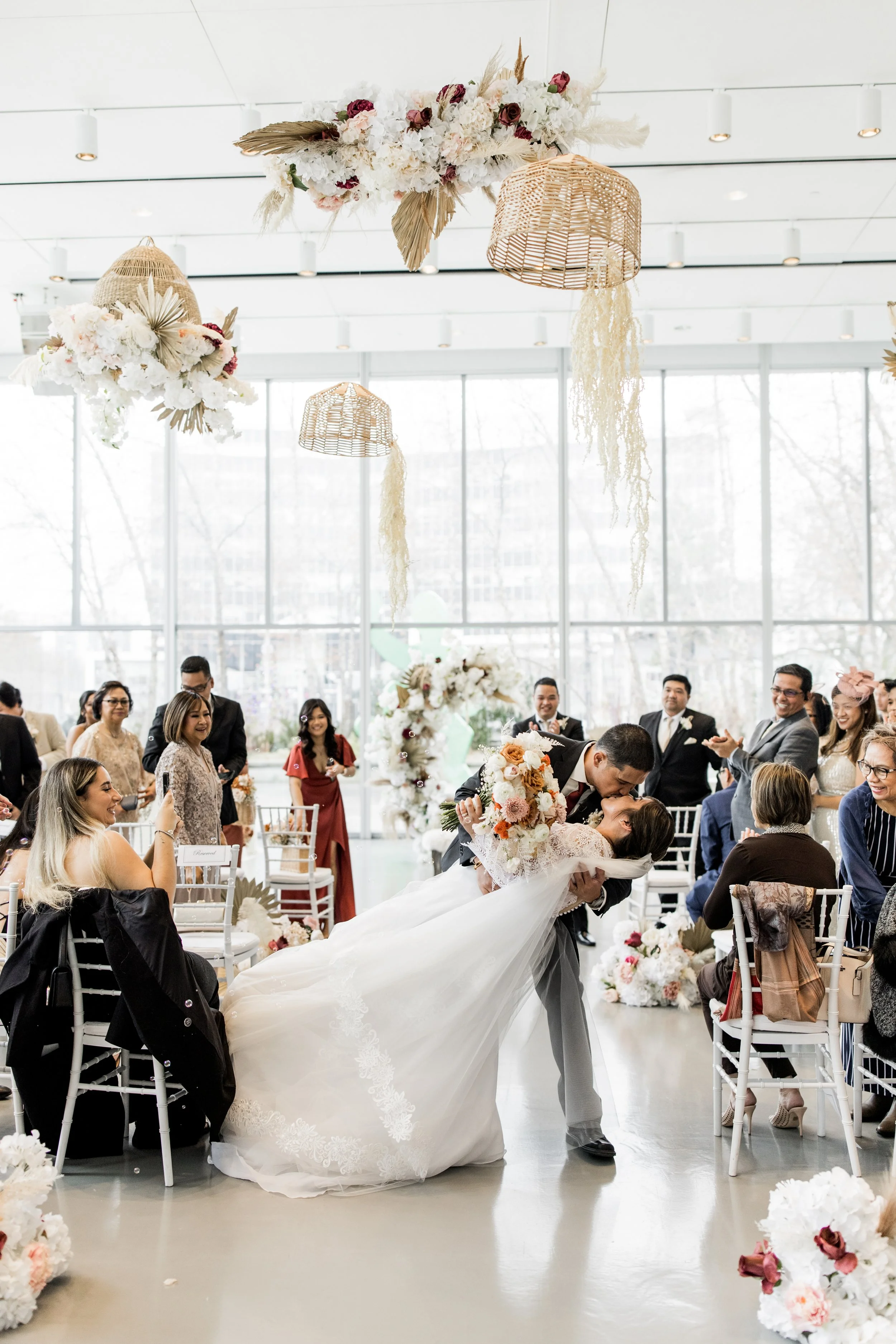 A wedding ceremony with a bride and groom sharing a kiss as the groom dips the bride.