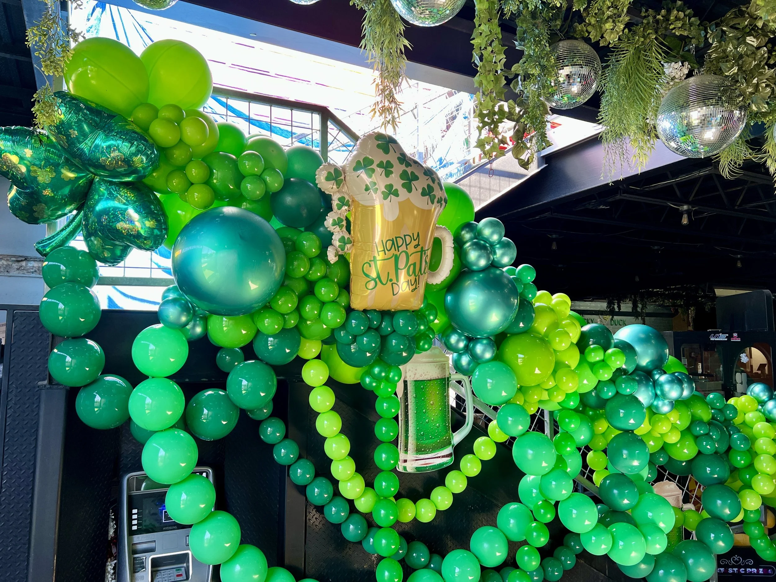 True Celebrations transformed Lucky Duck Bar for St. Patrick’s Day with a custom organic balloon garland cascading along the staircase. Featuring festive green balloons and vibrant holiday styling, this installation created a fun and memorable atmosp