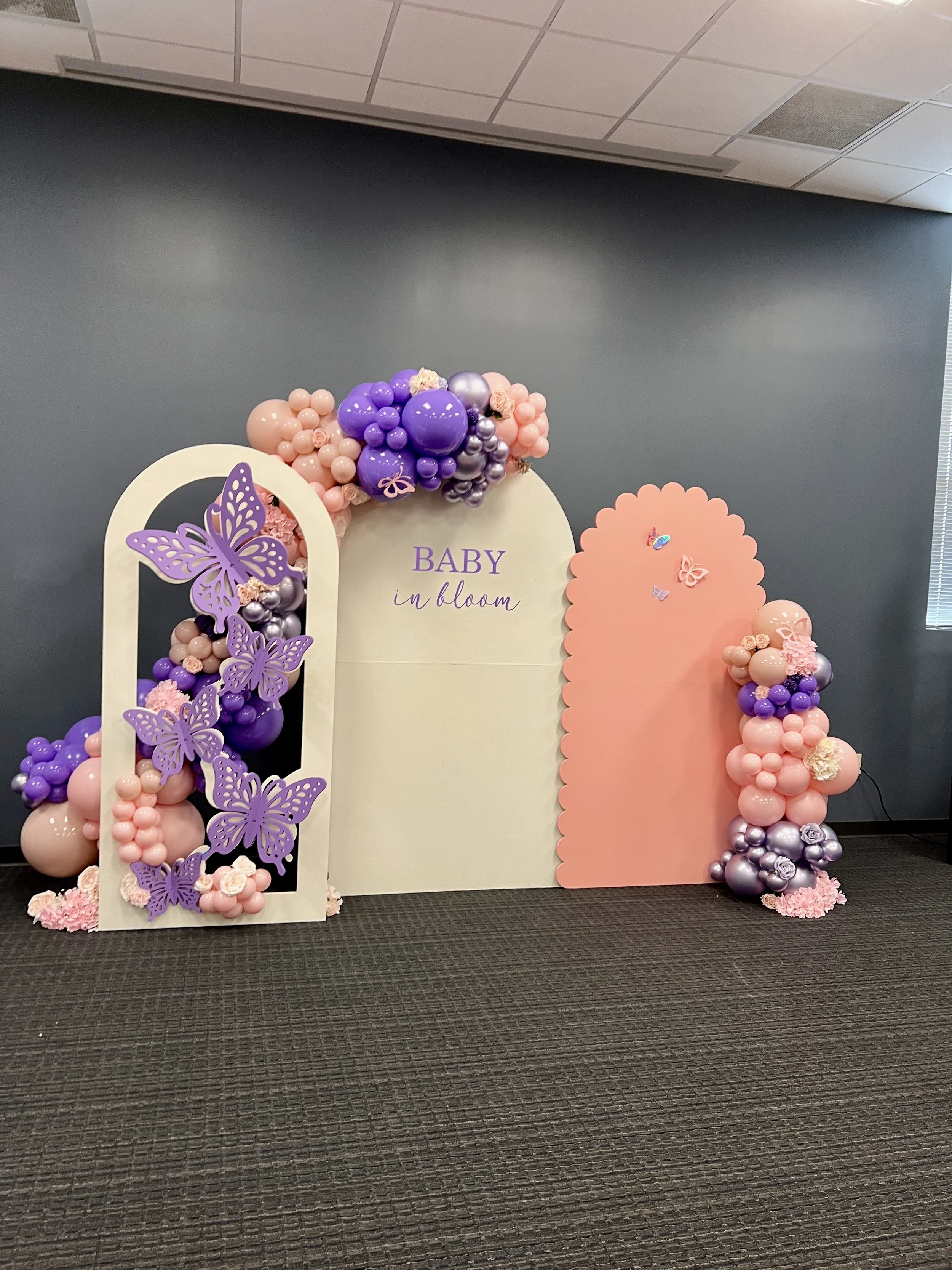 An elegant butterfly themed baby shower featuring a custom balloon backdrop in shades of purple, pink, and lavender. This luxurious celebration at Red Oak Ballroom was designed with organic balloon décor and personalized details to create a beautiful