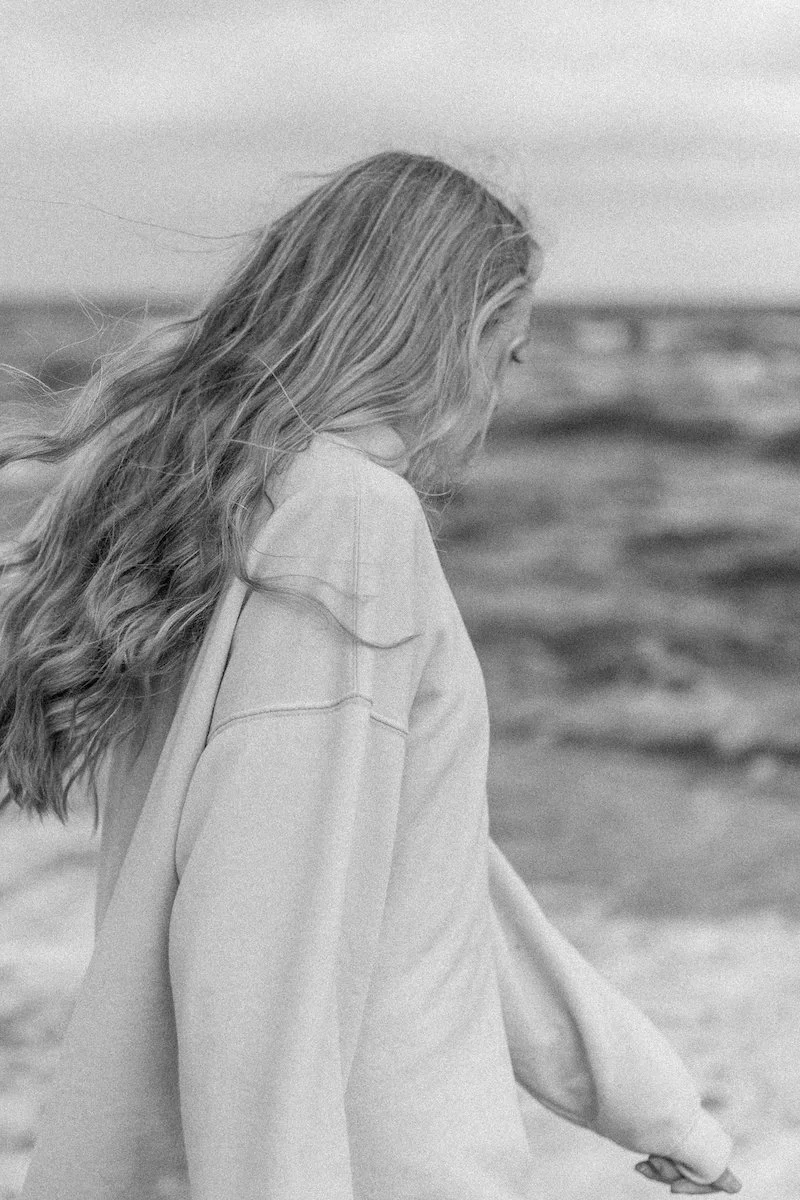 Black and white cropped photo of Sherise Adkins walking along the beach