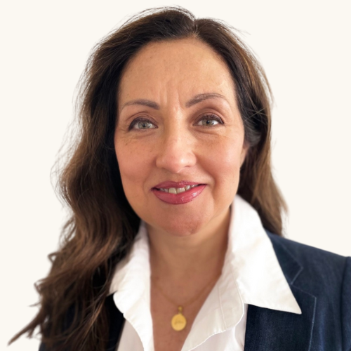 Mabel Mompo, a woman with brown hair and a friendly smile, dressed in a white blouse and navy blazer, against a plain white background.