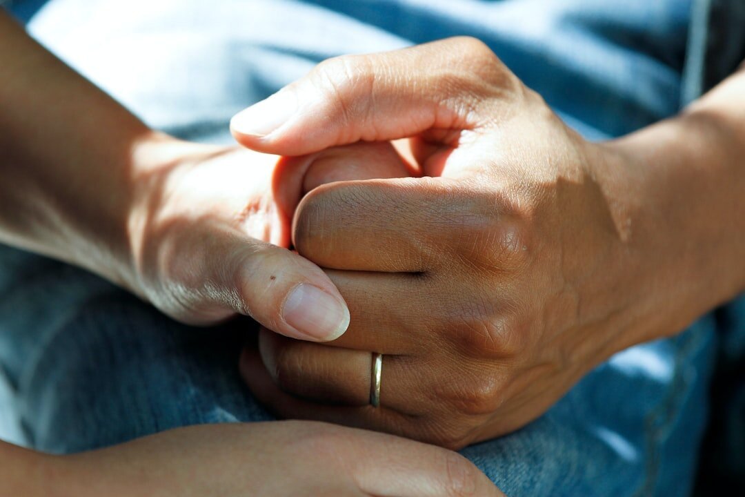 A close up of two people holding hands.