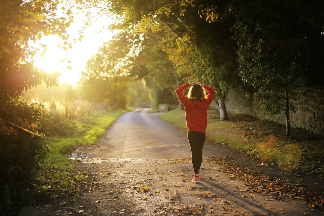 A woman walking on a country road.