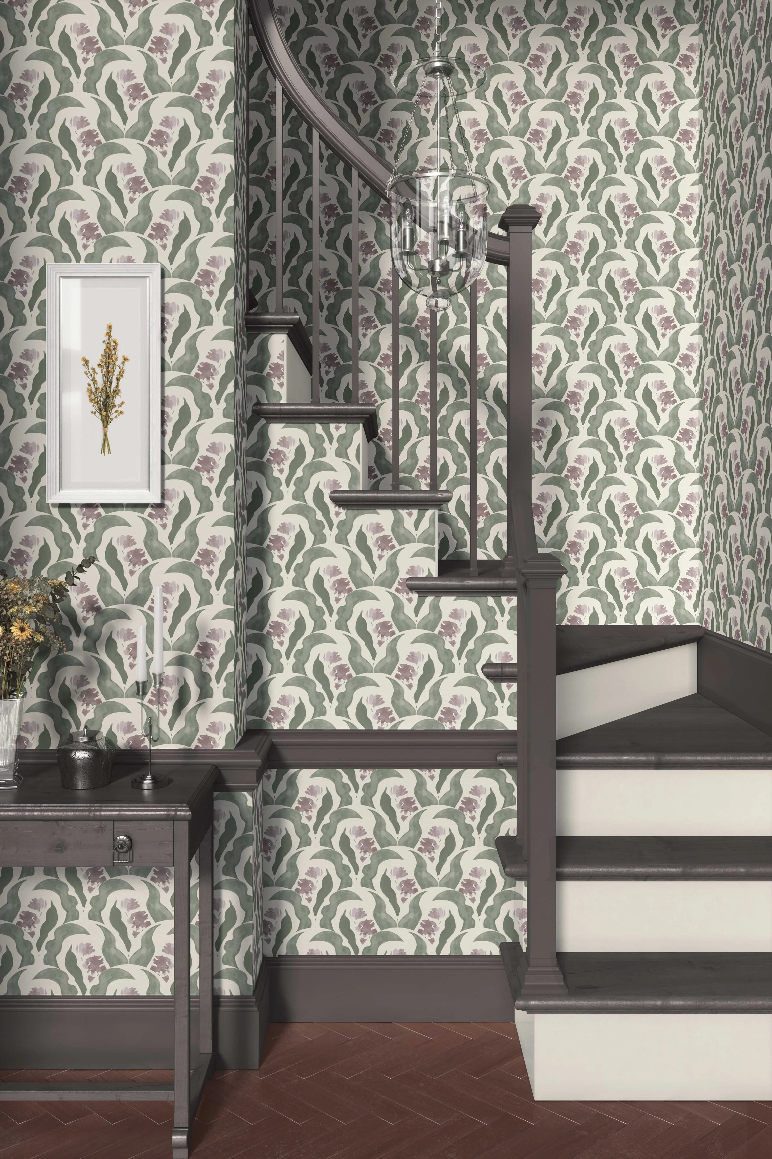 Interior staircase area with floral wallpaper, a small gray desk with a drawer, a vase with dried flowers, and a framed botanical print on the wall. The stairs have dark gray steps with a lighter gray interior side.