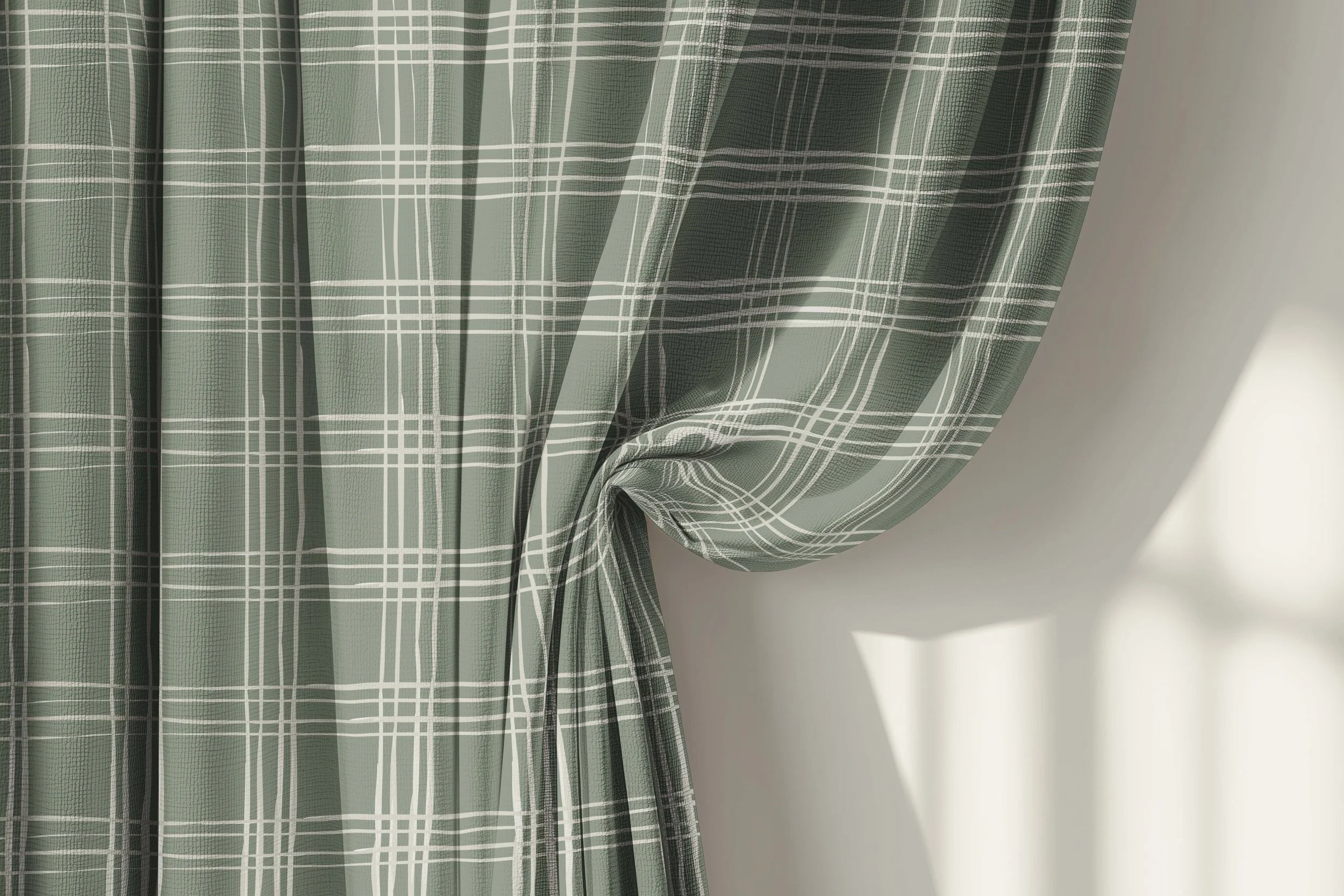 Green plaid curtain with white lines hanging in front of a white wall, slightly gathered to one side.