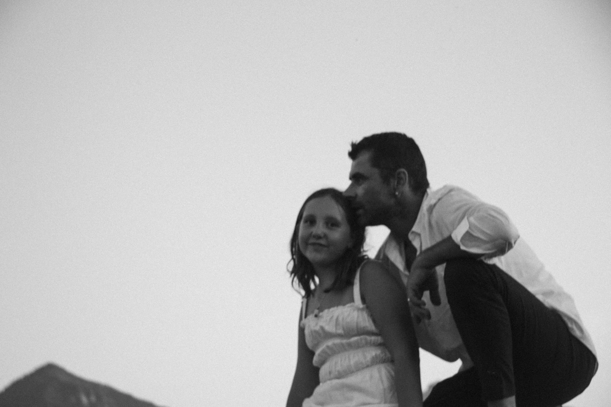 family photoshoot - A man and his daughter outdoors with mountains in the background, in black and white.
