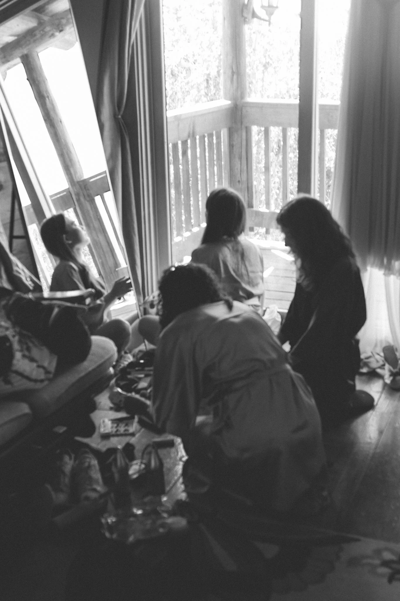 wedding day - bridesmaids getting ready in front of a mirror sitting in a circle