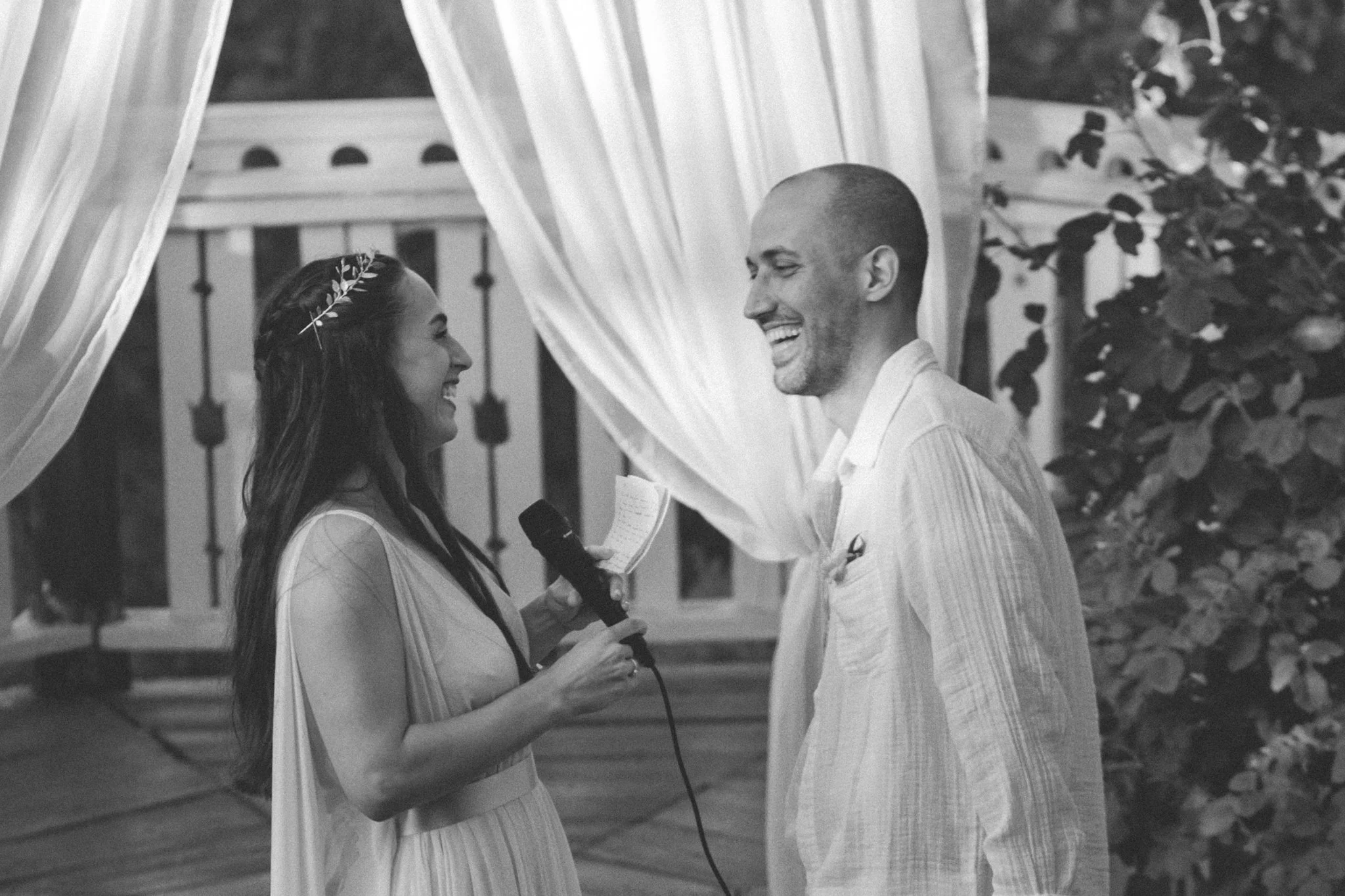 wedding day - the couple is delivering their vows to each other in front of their friends and family. smiling