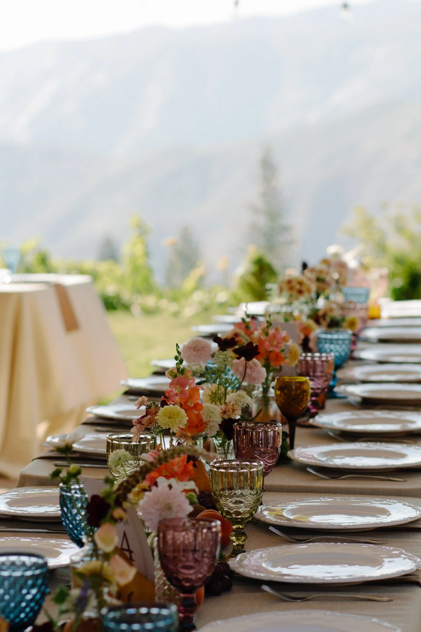 wedding day - the table setting is colorful with beautiful flower arrangements and glassware 