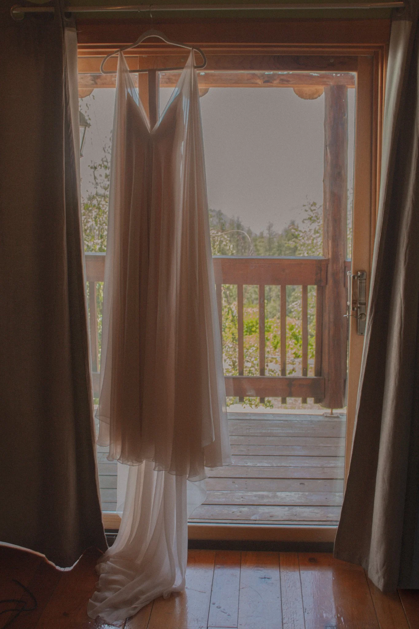 wedding day - the beautiful wedding dress hanging by the window