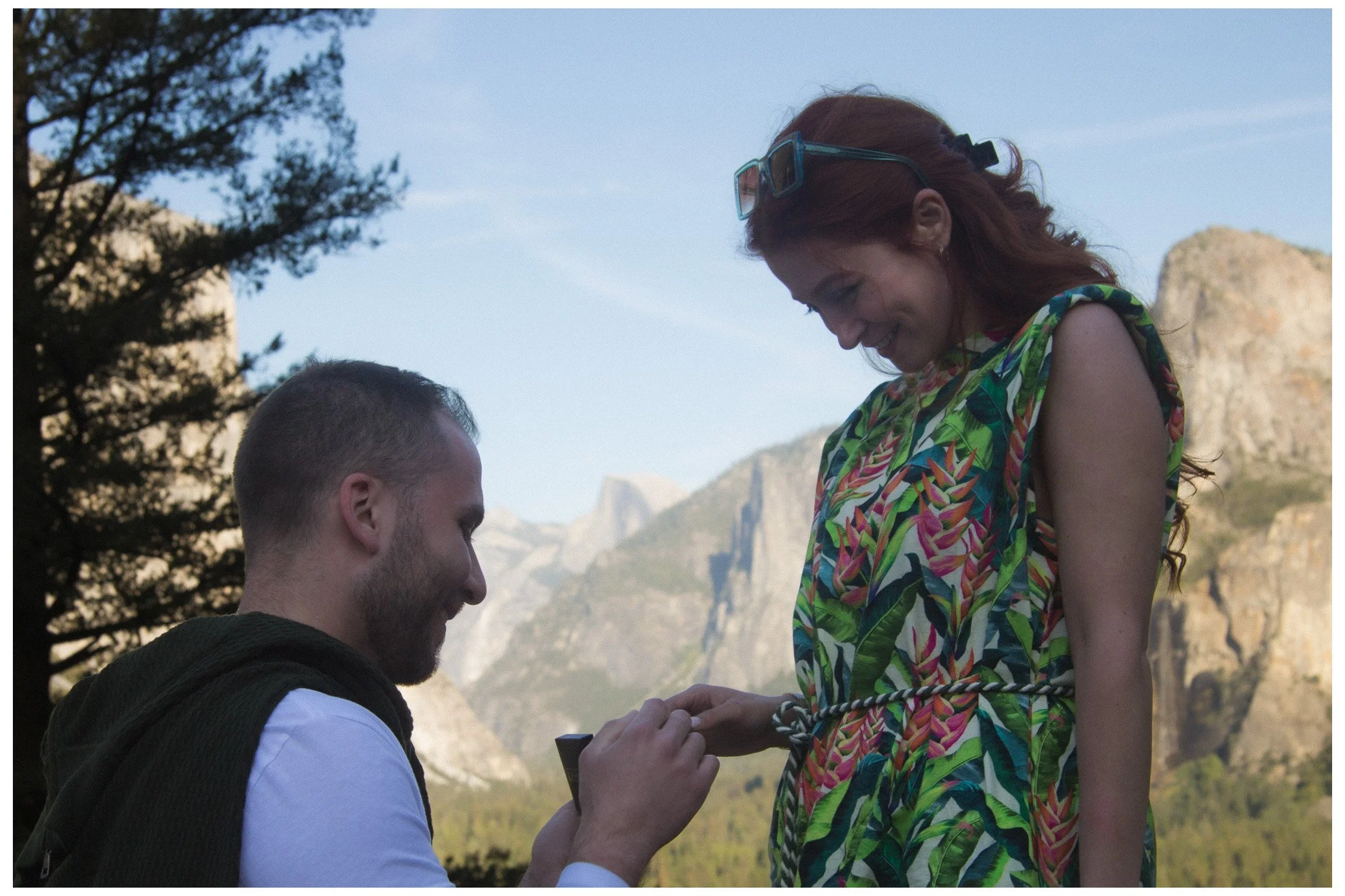 engagement / couple - man on his knees to propose to his girlfriend. putting the ring on her finger